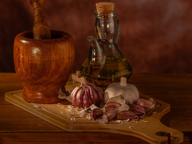 Garlic and pumpkin seed oil with a kitchen mortar on the table