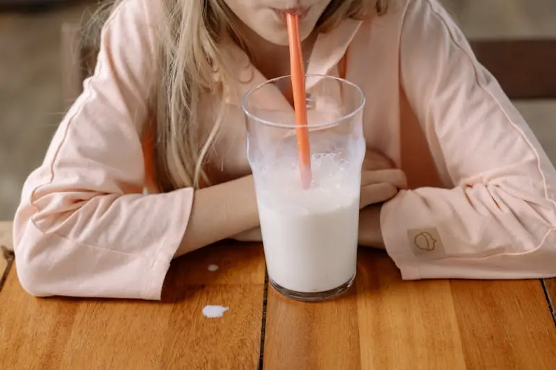 young girl drinking a glass od milk