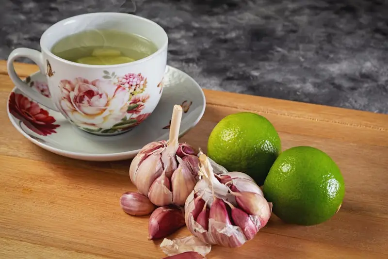 garlic with limes and cup of tea on the table
