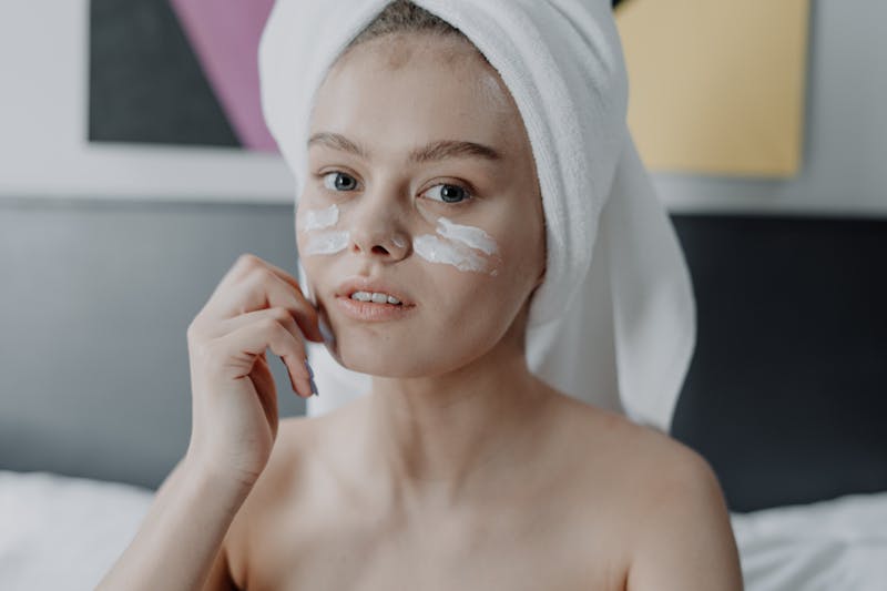 Young woman applying a garlic-based cream to her face