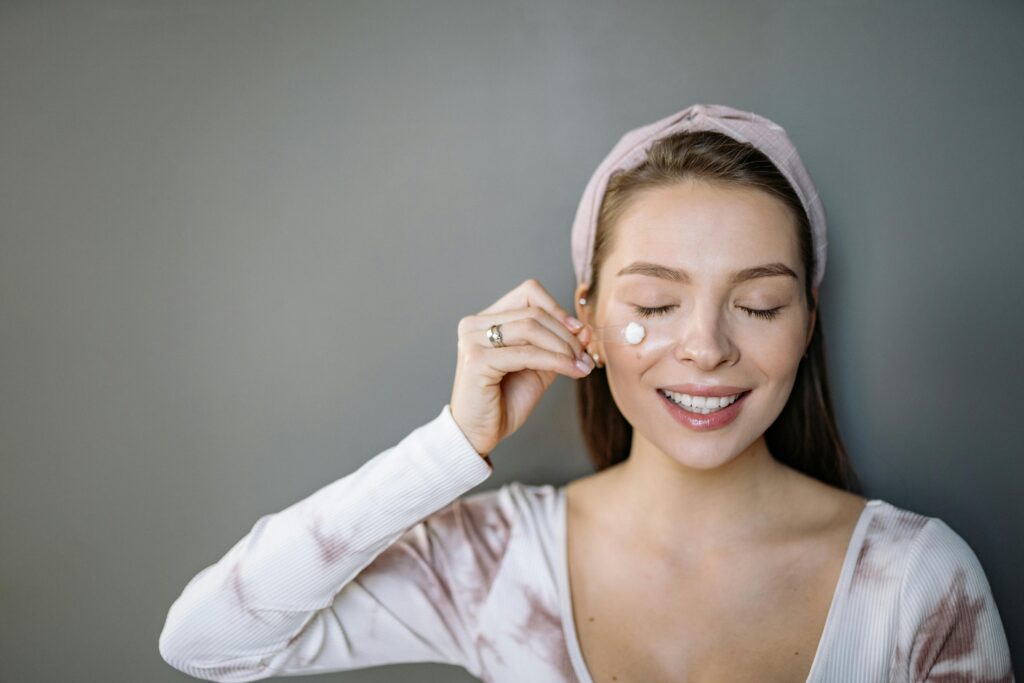 Young woman applying a garlic clove directly to an acne spot on her face
