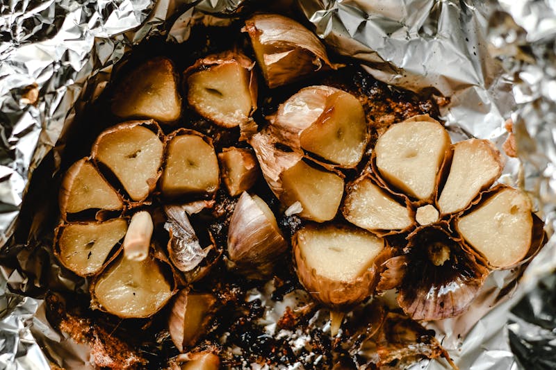 roasted garlic bulbs cut in half in aluminum foil
