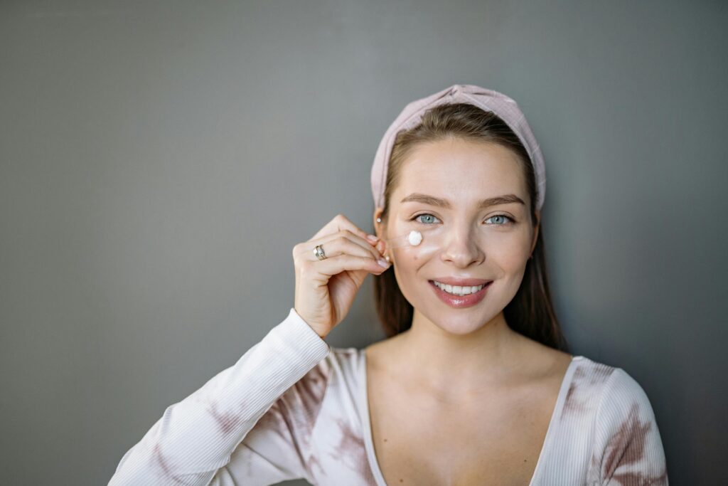 Smiling young woman holding a garlic clove against her face