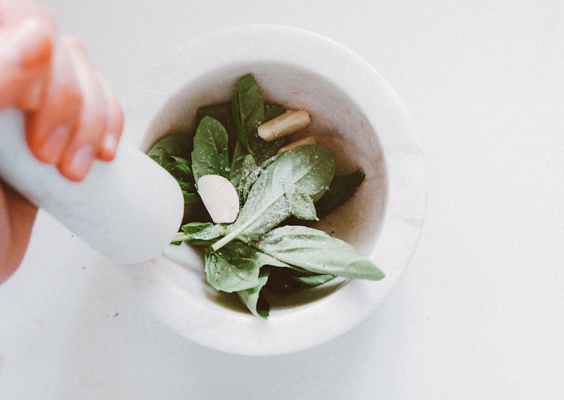 garlic, spinach and salt ina mortar