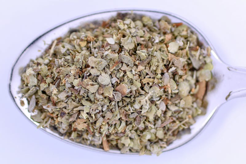 dried and crushed lemon balm on a spoon