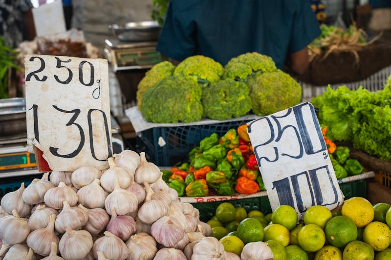 Fresh garlic bulbs and bright green limes displayed on a market stall