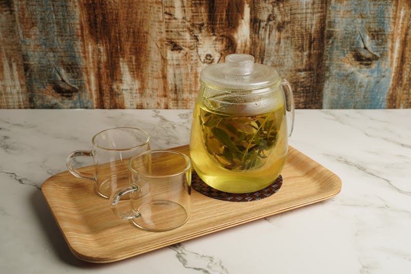 lemon balm tea in herb infuser and two empty glasses