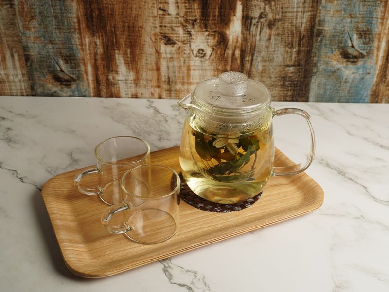 a jug with lemon balm tea with 2 empty glasses