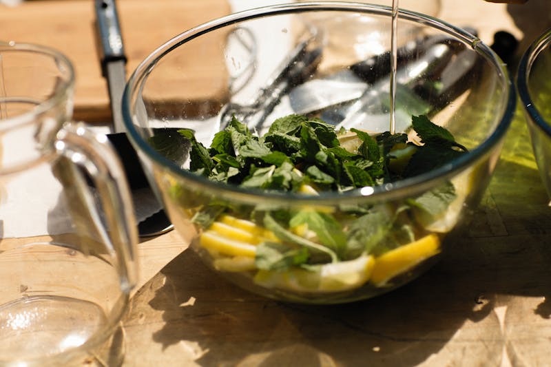 fresh lemon balm leaves with chopped lemon in a bowl