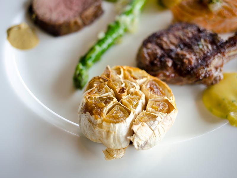 roasted garlic and meat on a plate