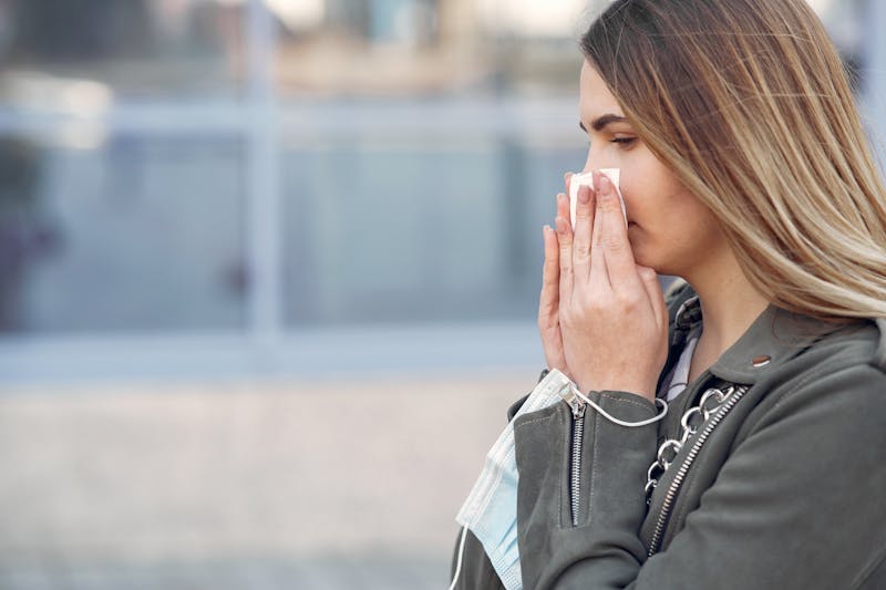 woman blowing nose with garlic allergy symptoms