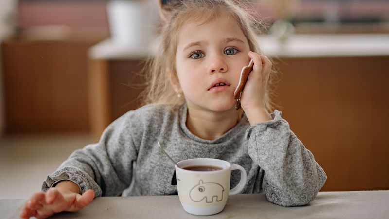 a child sitting and drinking lemon balm tea