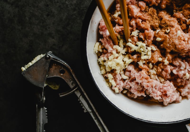 crushed garlic and meat in a bowl