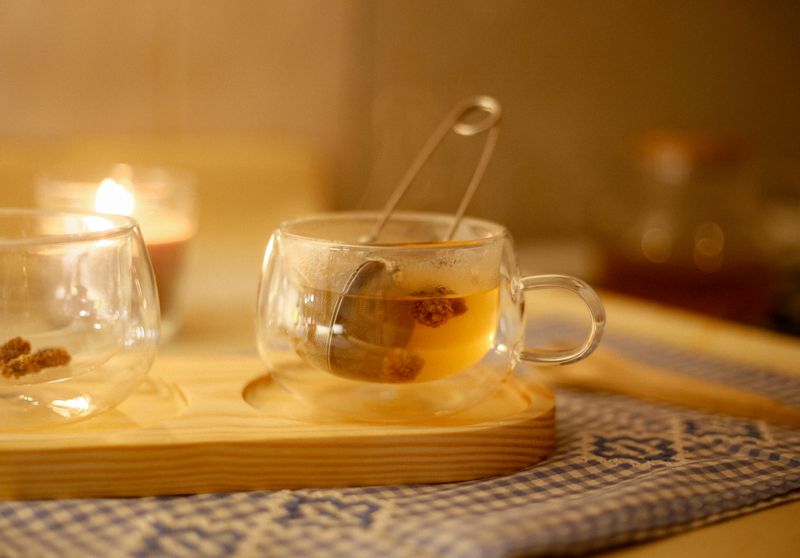 a small cup of lemon balm tea with tea ball