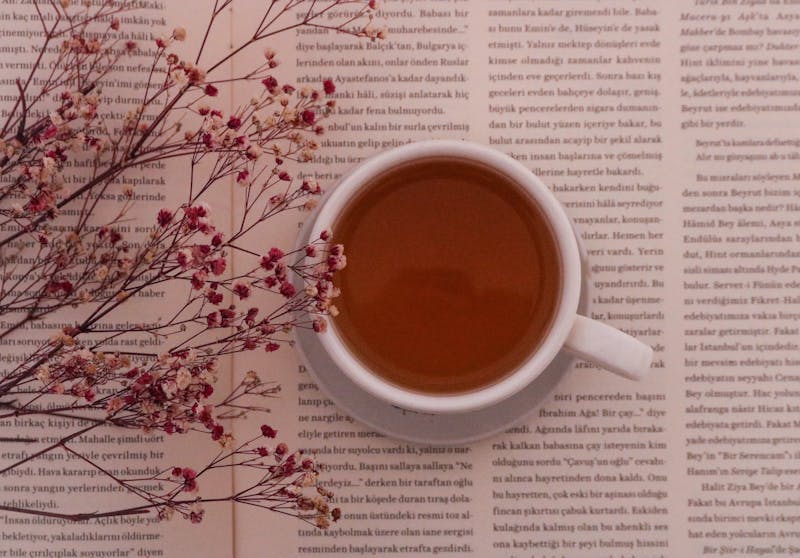 a cup of chamomile tea is standing on an open book