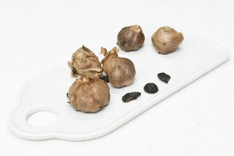 black garlics on a chopping board