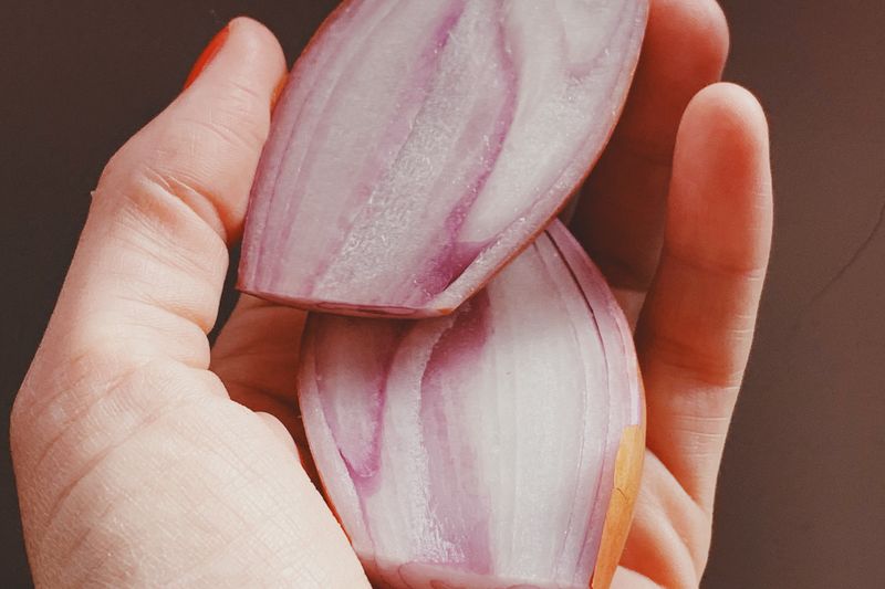 shallot cut in half on the hand